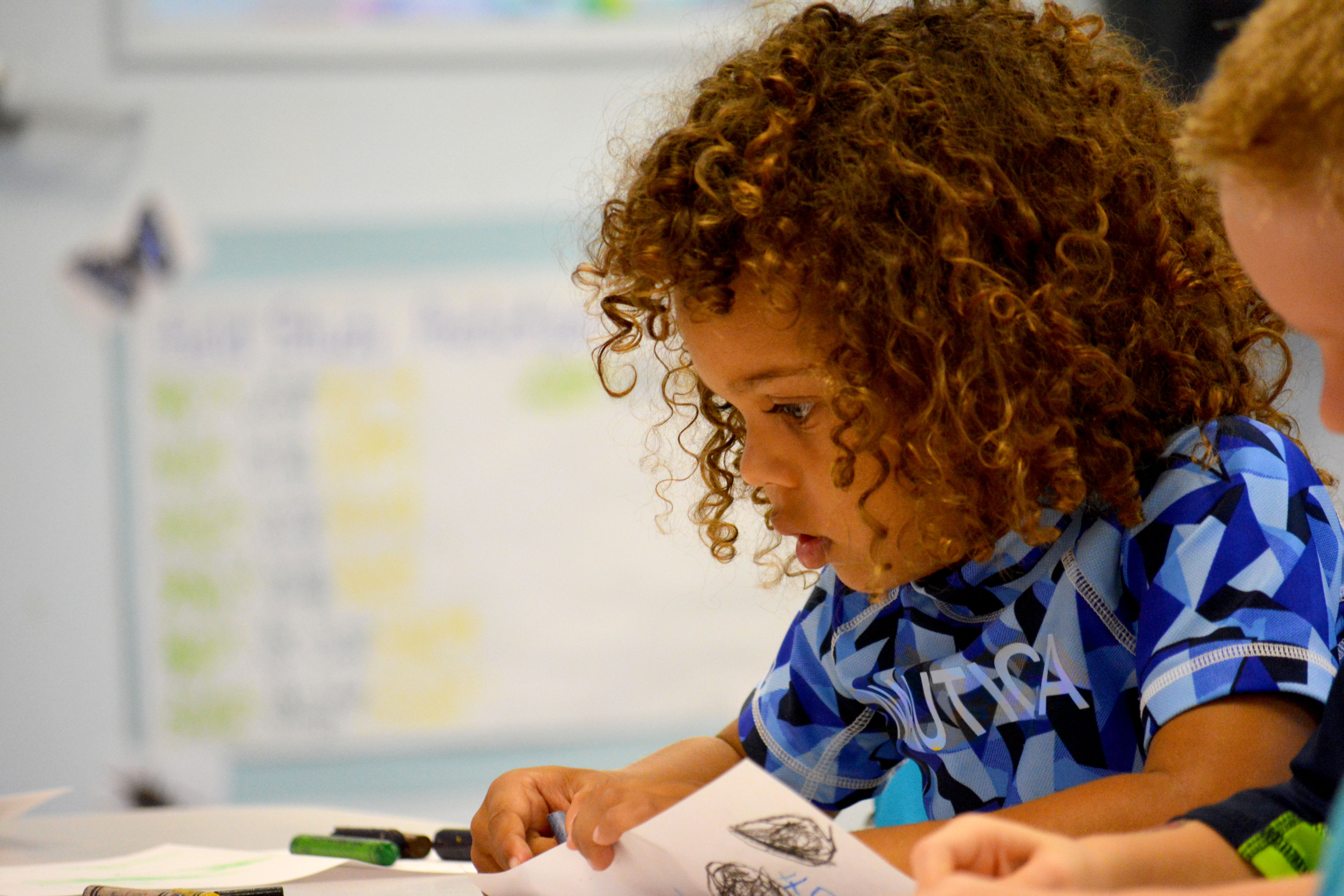 curly haired boy blue shirt concentrating