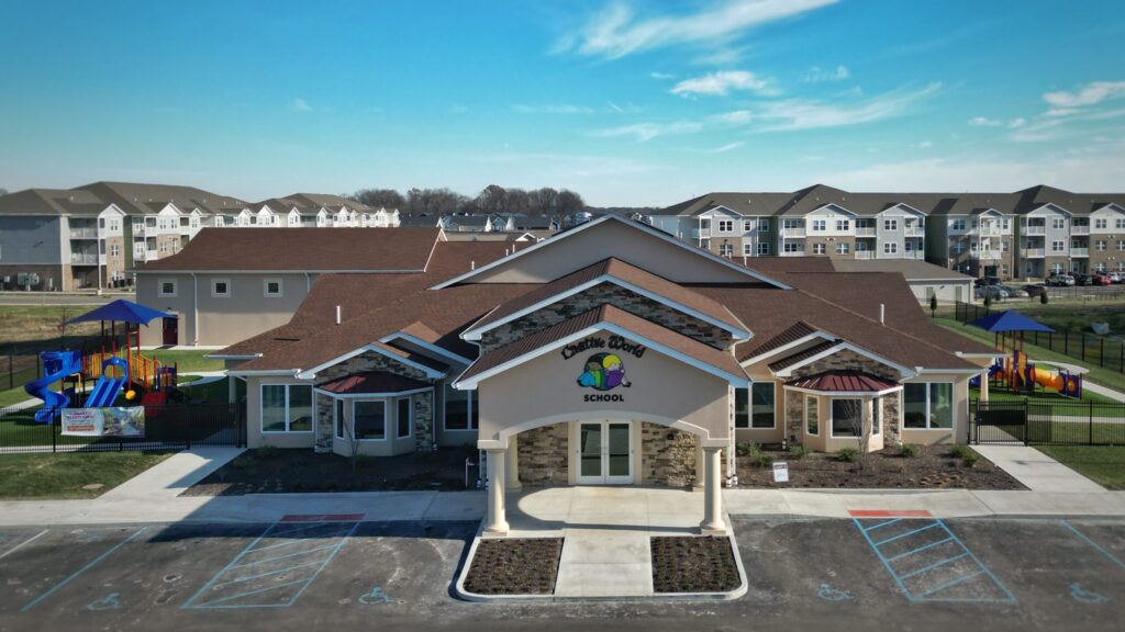Front view of Creative World School Franklin Township, showcasing the main entrance, colorful playground, and surrounding community buildings.