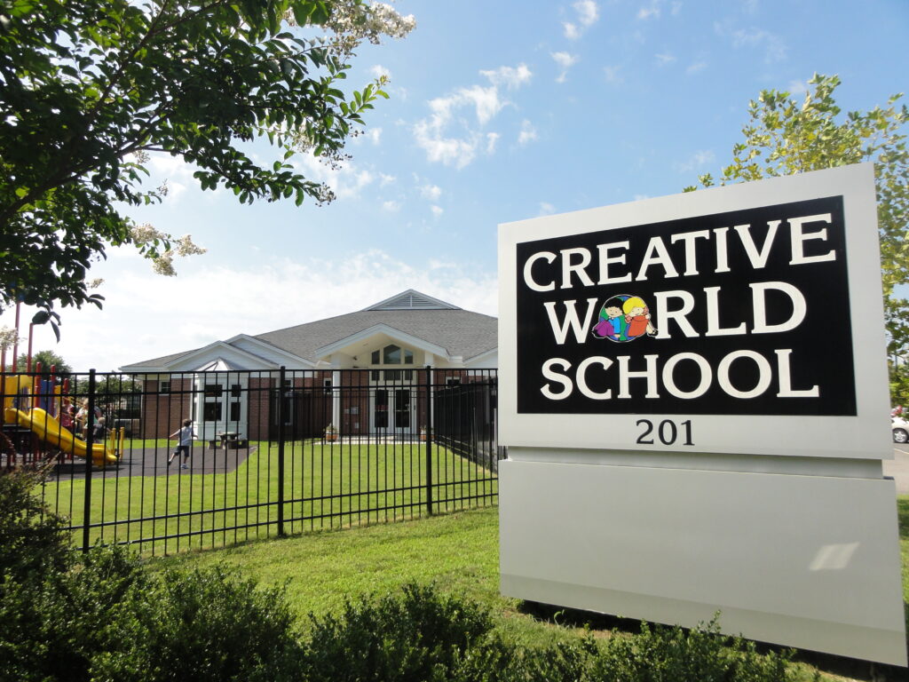 Front view of Creative World School at River Walk, featuring the building, playground, and school sign.