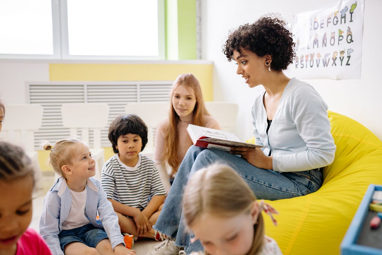 Woman reading a book to the children