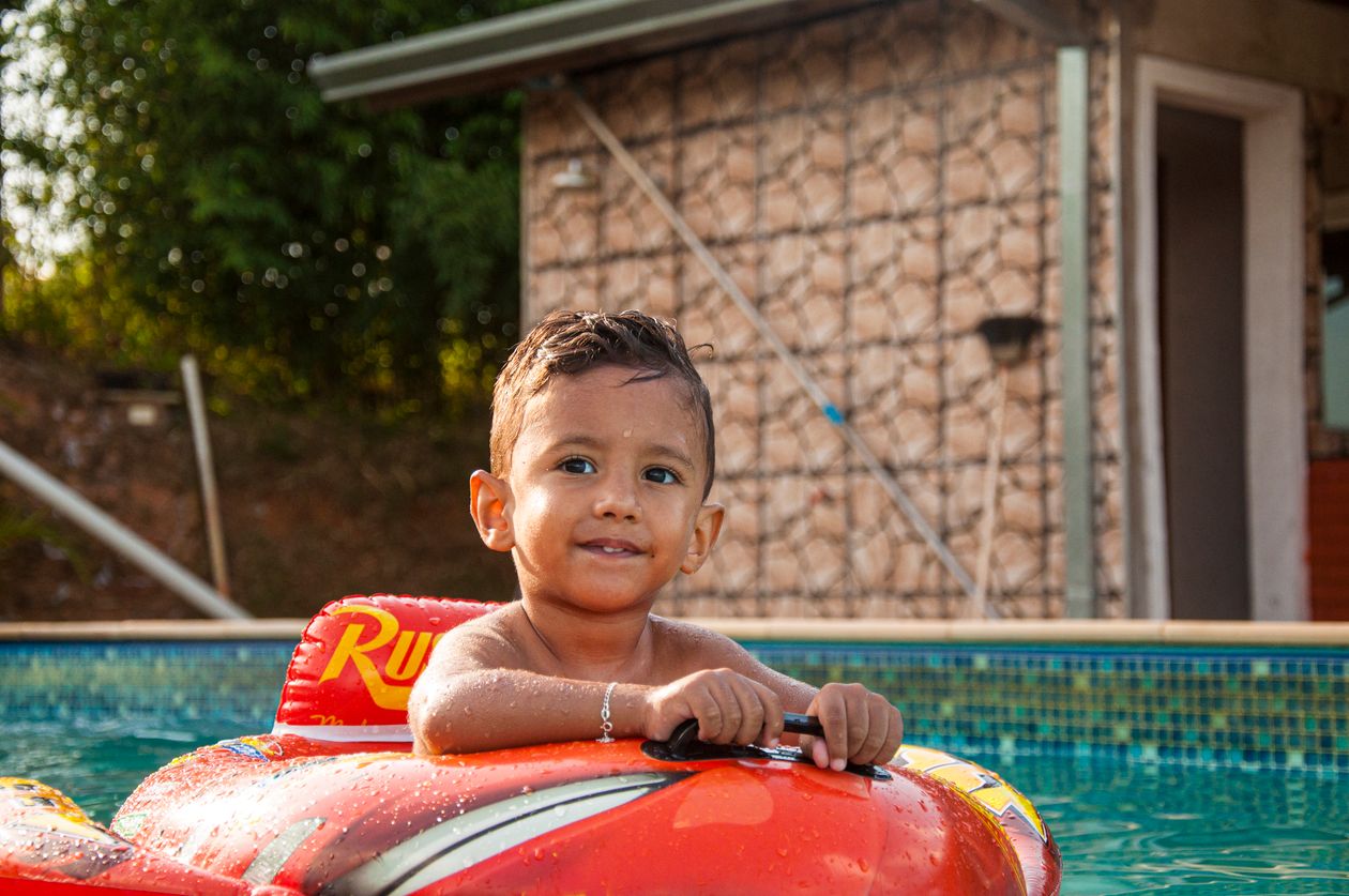 Cute child in inflatable ring in swimming pool