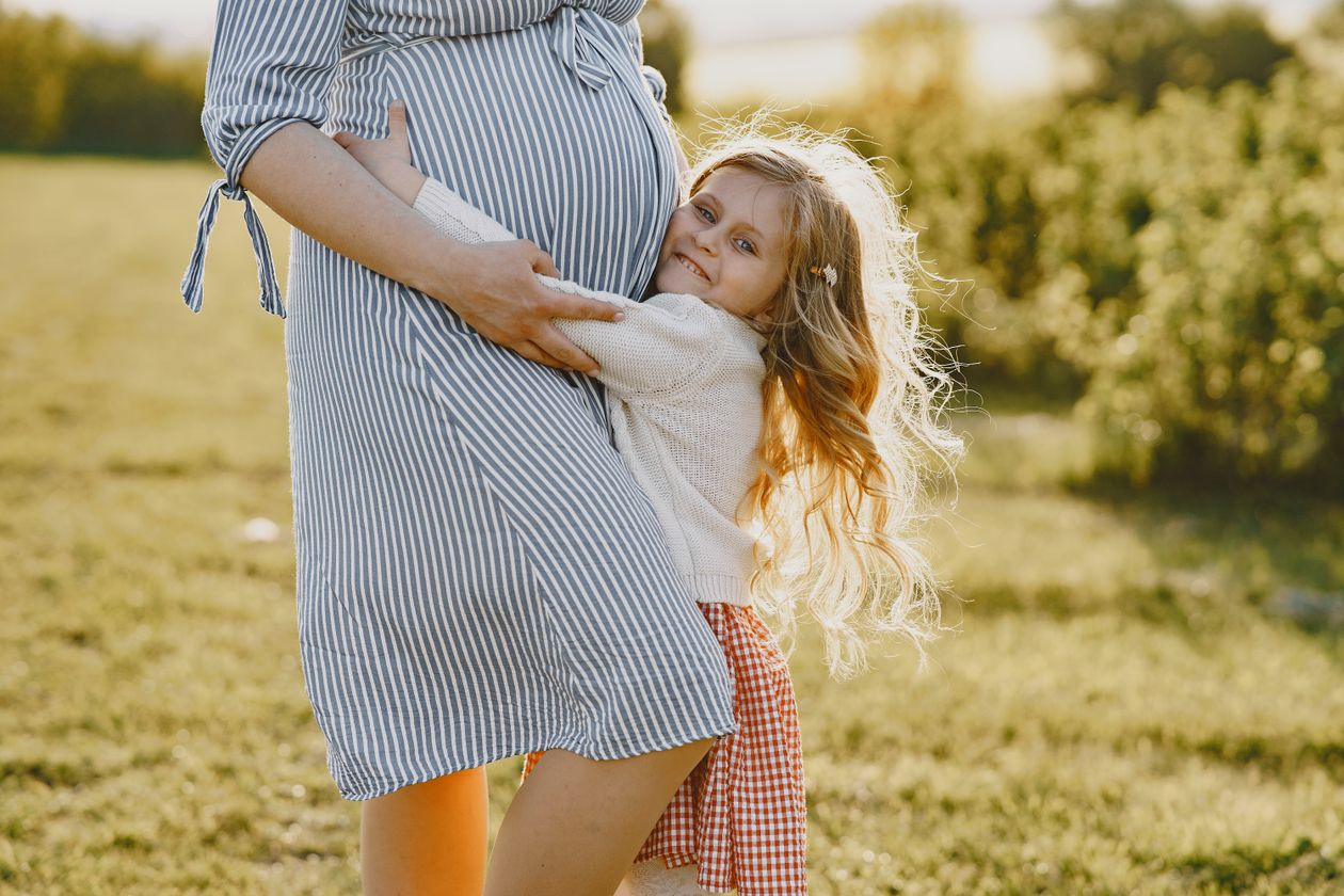 A girl hugging her pregnant mother