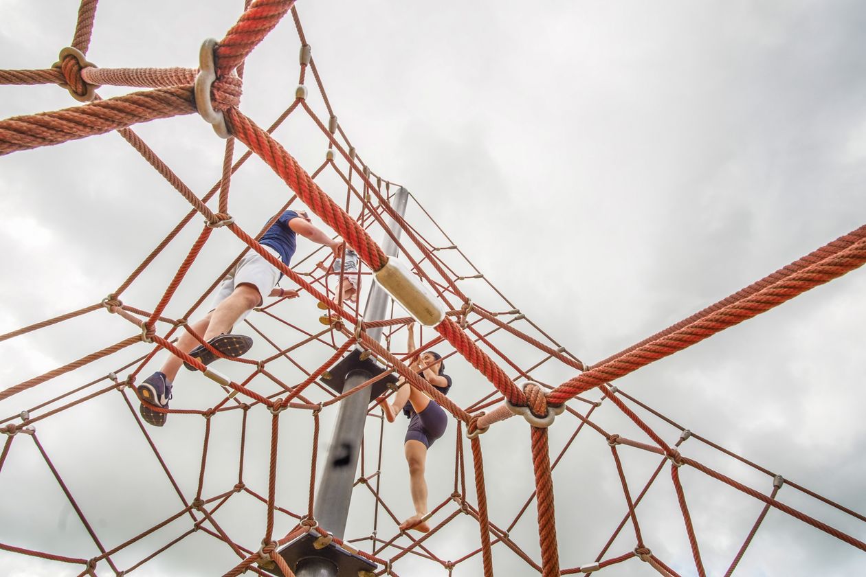 Children climbing rope playground structure outdoors
