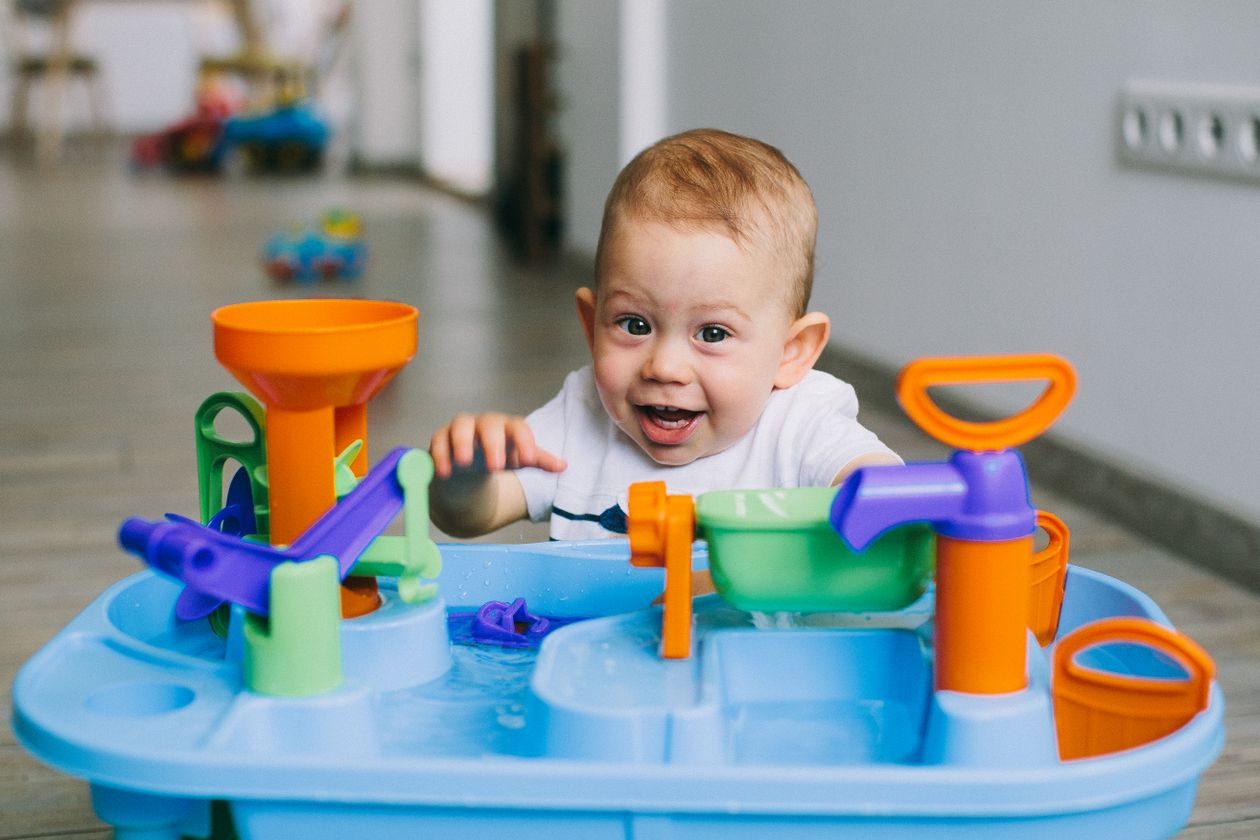 Cute toddler playing with water at the sink