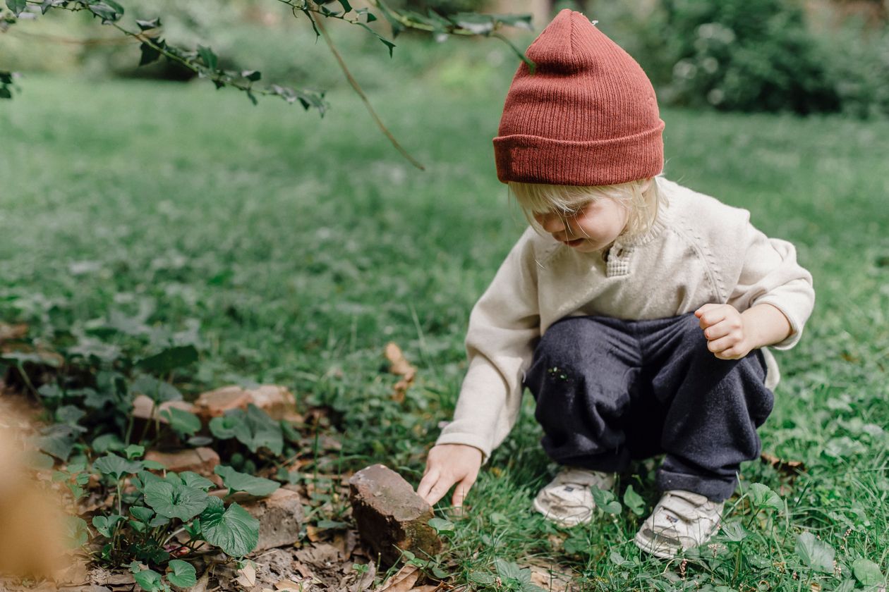Interested little boy exploring a stone outdoors