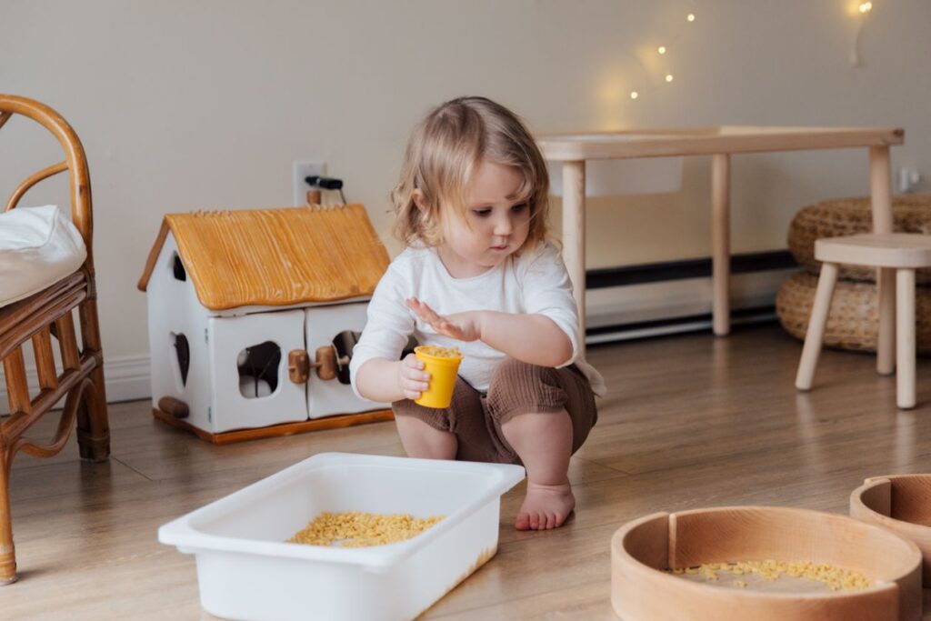 Girl holding yellow plastic cup full of macaroni