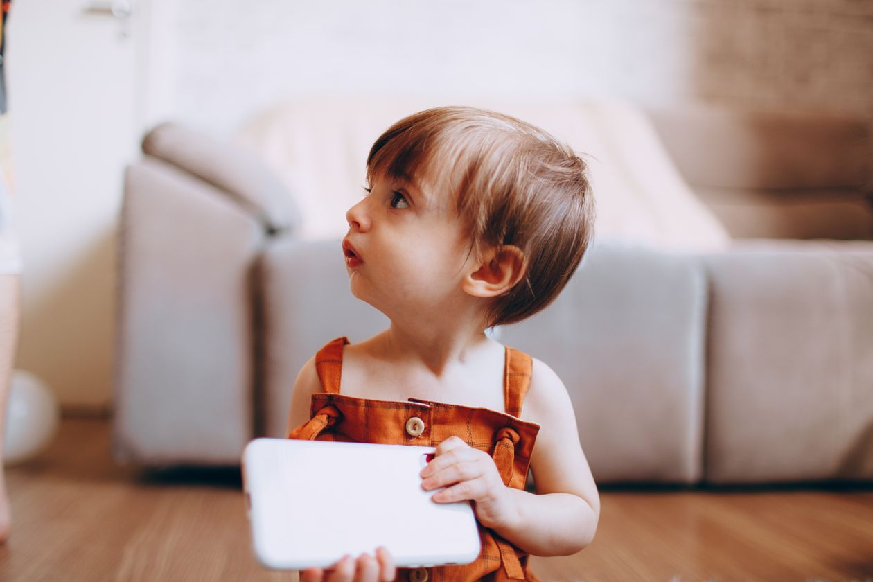 Curious toddler with tablet at home