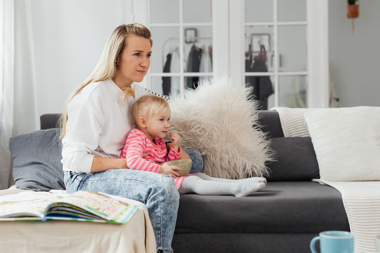 Woman watching TV with toddler daughter